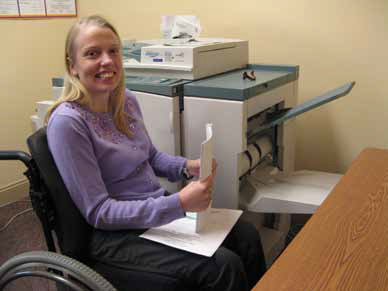a photo of a girl working in an office using a wheelchair