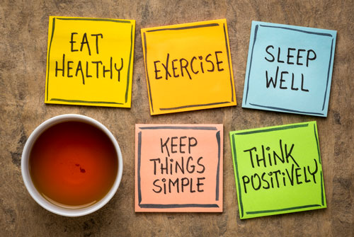 a photograph with a cup of tea and post its that read Eat Healthy, Exercise, Sleep Well, Keep Things Simple, Think Positively