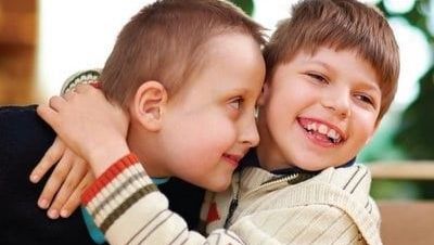 a photo of two brothers hugging, one has down syndrome