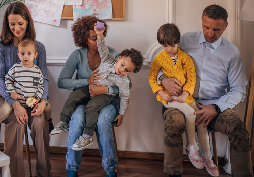 parents sitting on chairs with their children in their laps