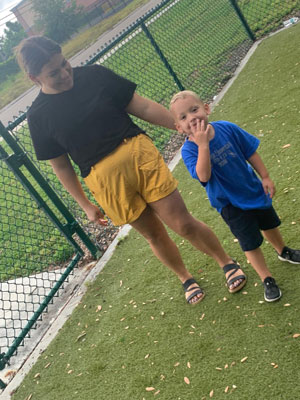 Courtney smiling with her son in their back yard