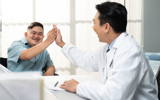 a man with Down Syndrome high fiving his doctor