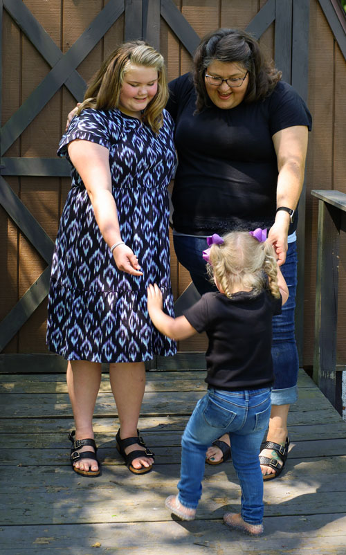 Tiffany Wilson smiling with her foster children outside near a shed